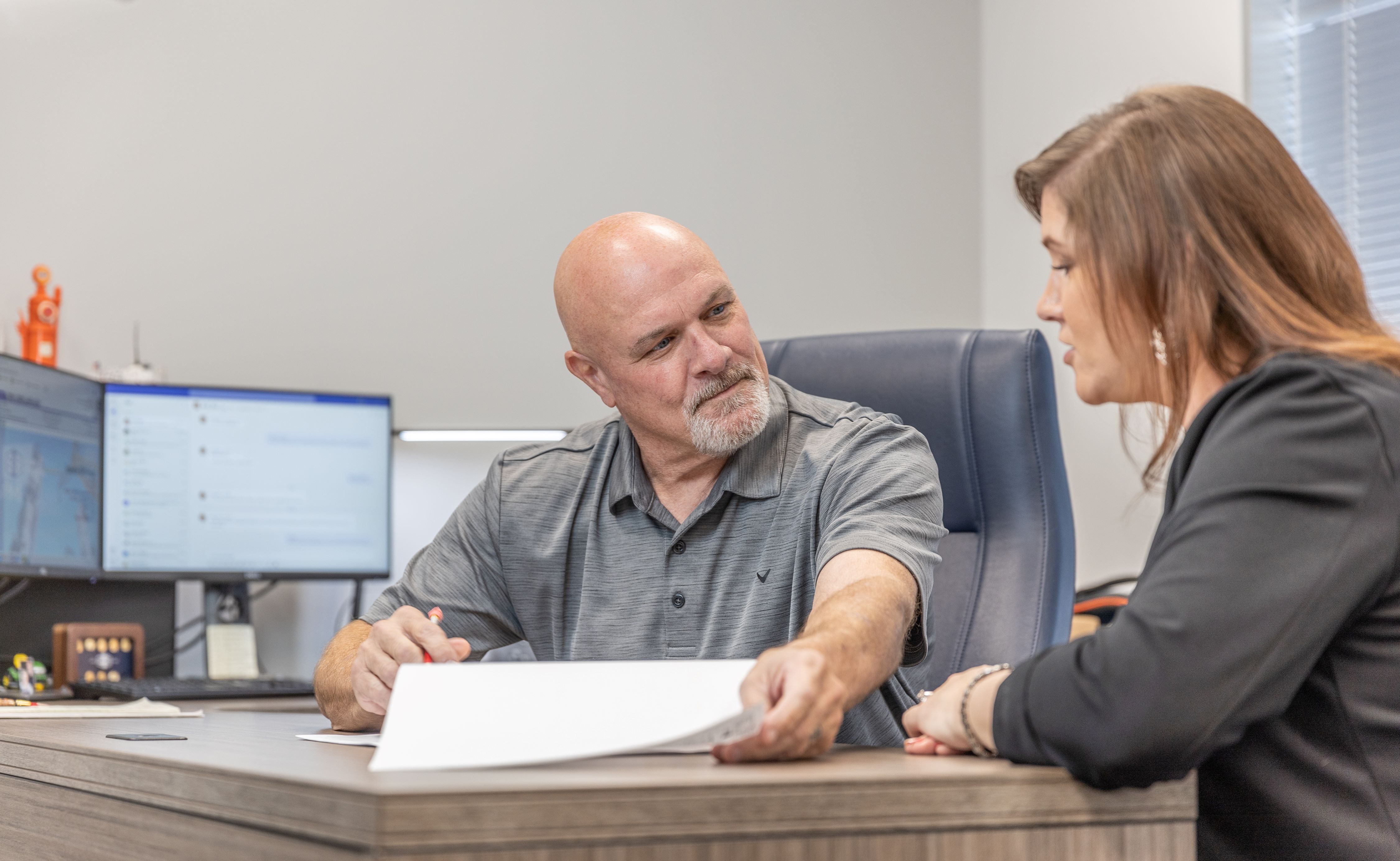 S&B employees talking at a desk