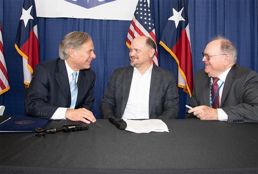 Greg Abbott at a speakers table with S&B Senior Leadership