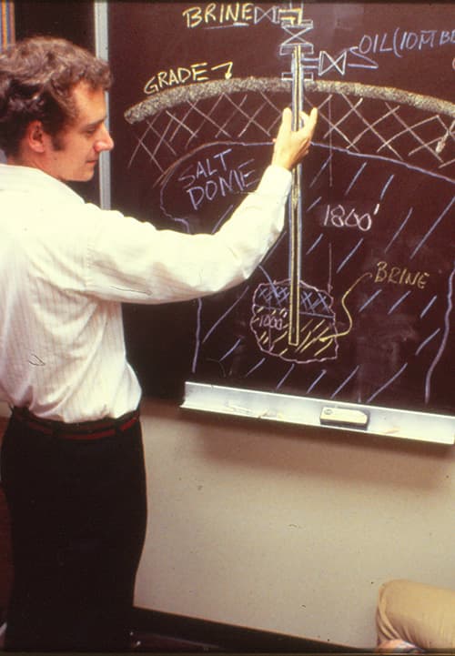 An S&B engineering designing salt domes on a blackboard