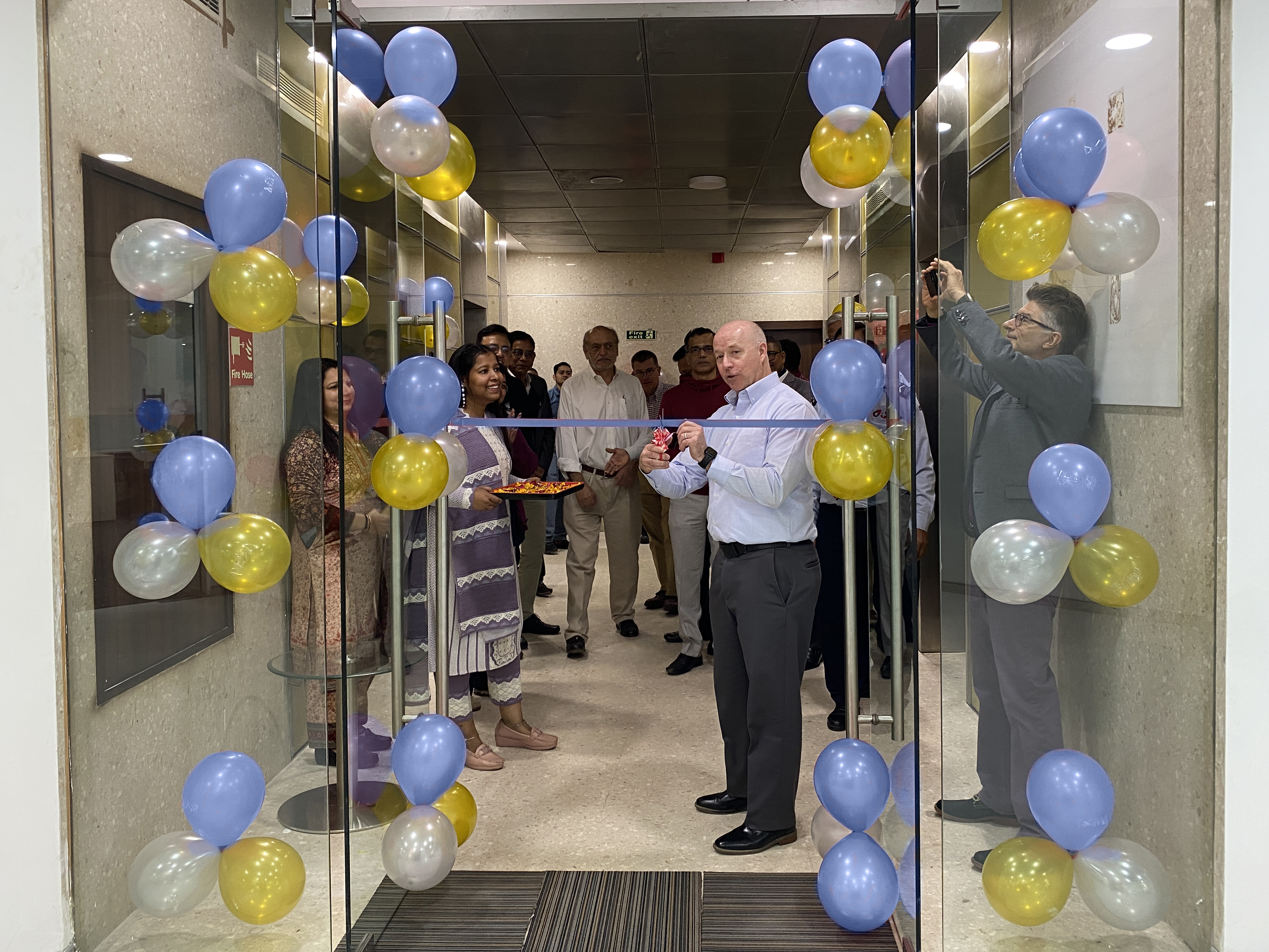 The S&B team stands ready with scissors to cut the ribbon in the doorway of the new, expanded S&B Office in Noida, India