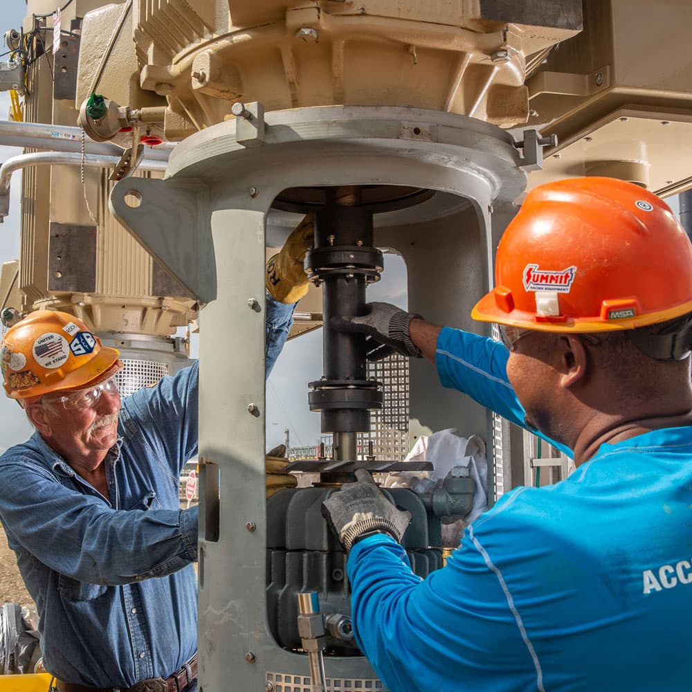 Two S&B craft workers adjusting a piece of equipment