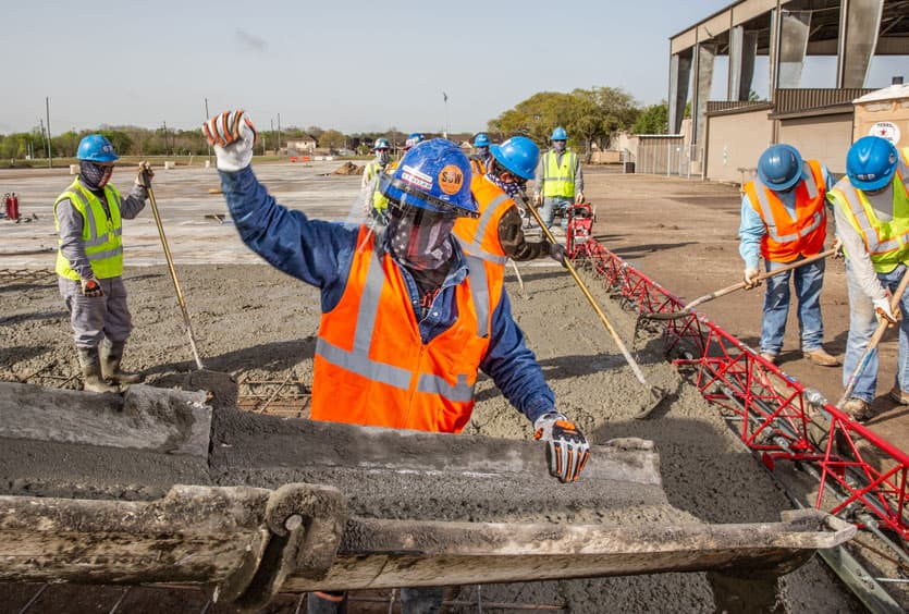 An S&B employee guiding cement down a trough