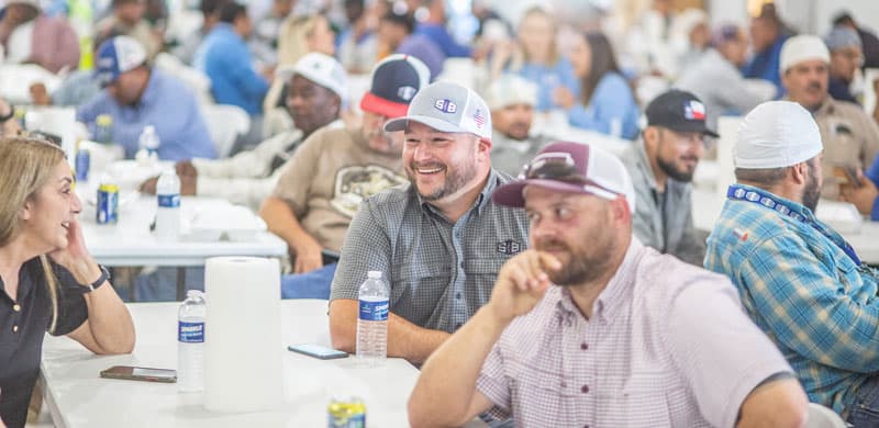 Employees at a company sponsored event laughing at a table