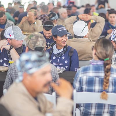 An S&B employee dressed in blue sitting amongst volunteers