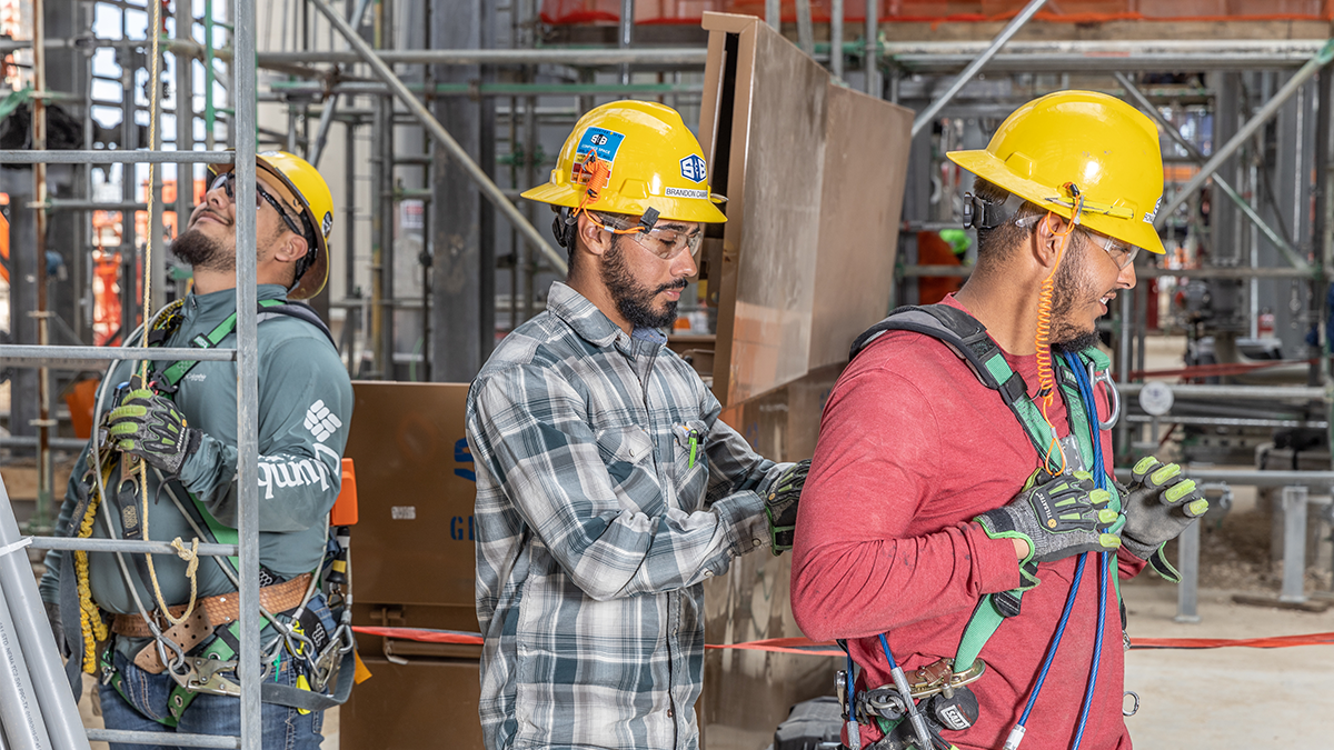 Man adjusting safety equipment on another man