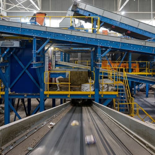 Materials on a platform going through a blue recycling conveyer belt