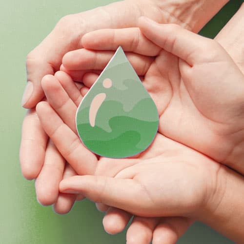 Hands holding a green water droplet sticker