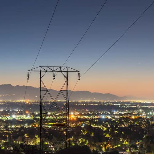 A large power line on top of a hill at night