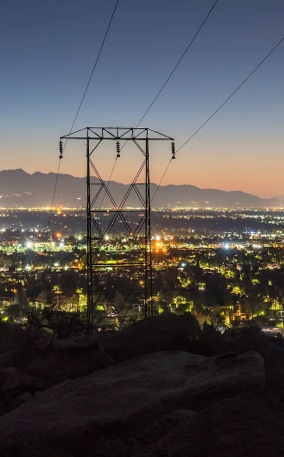 A large powerline on top of a hill at night