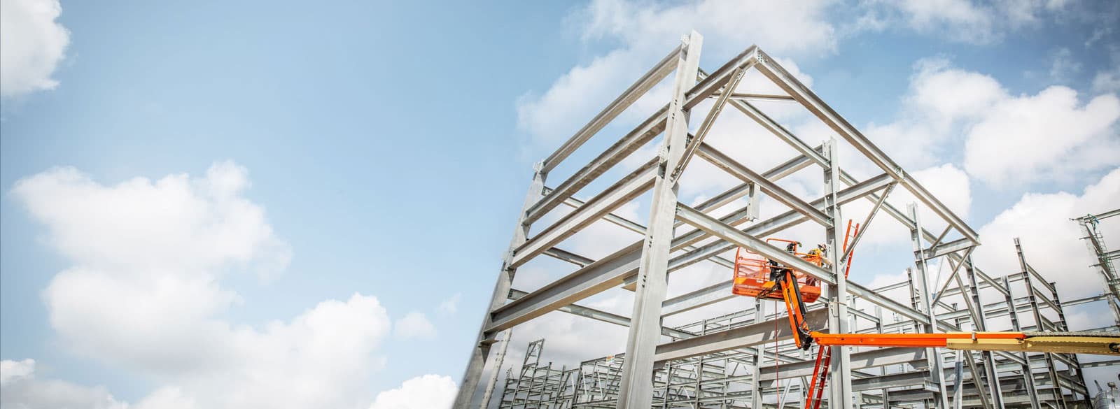 An S&B employee tightening structural supports while standing on a lift