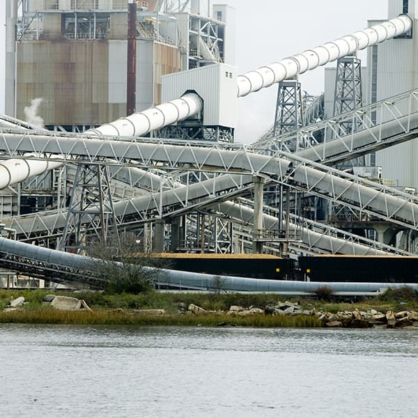 Large piping running across water at one of International Paper’s pulp & paper mills