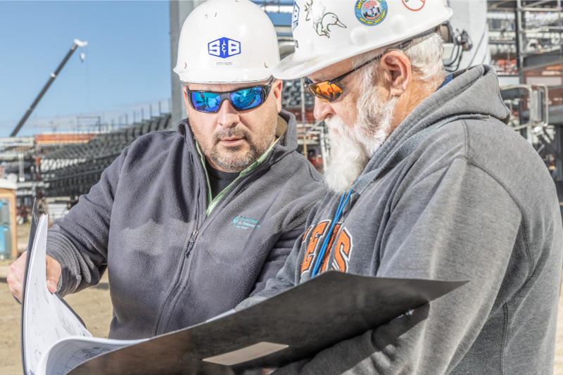 S&B construction workers looking over a plan side by side at a site